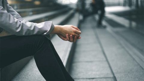 Businesswoman sits thinking, alone