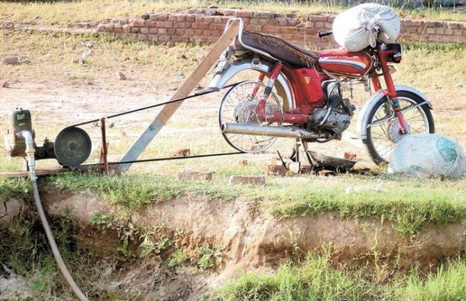 A motorbike's rear wheel has been adapted as a power source for a water pump