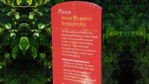 An outdoor sign asks please avoid harmful stereotypes